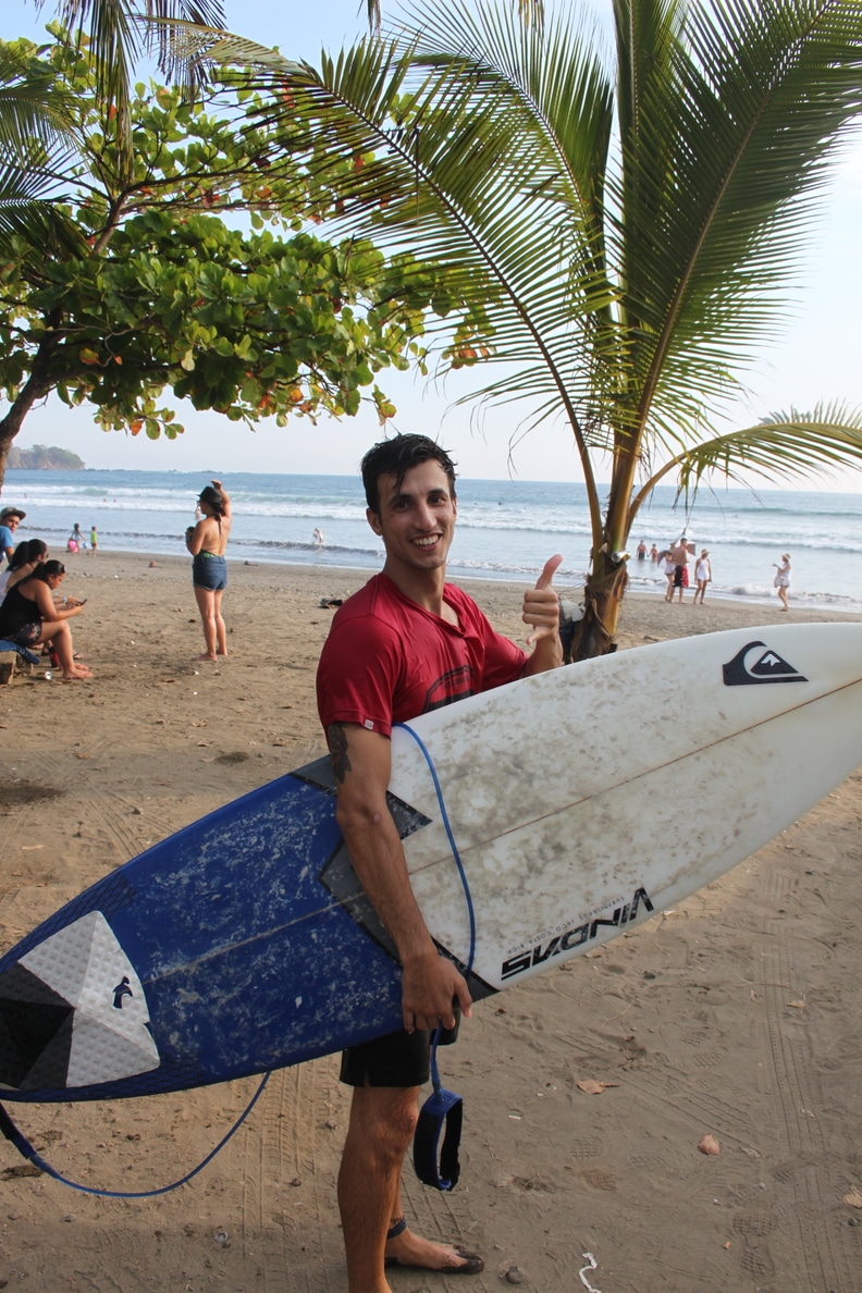 Damian, our front desk manager surfing at sunset at Room2Board Hostel and Surf School